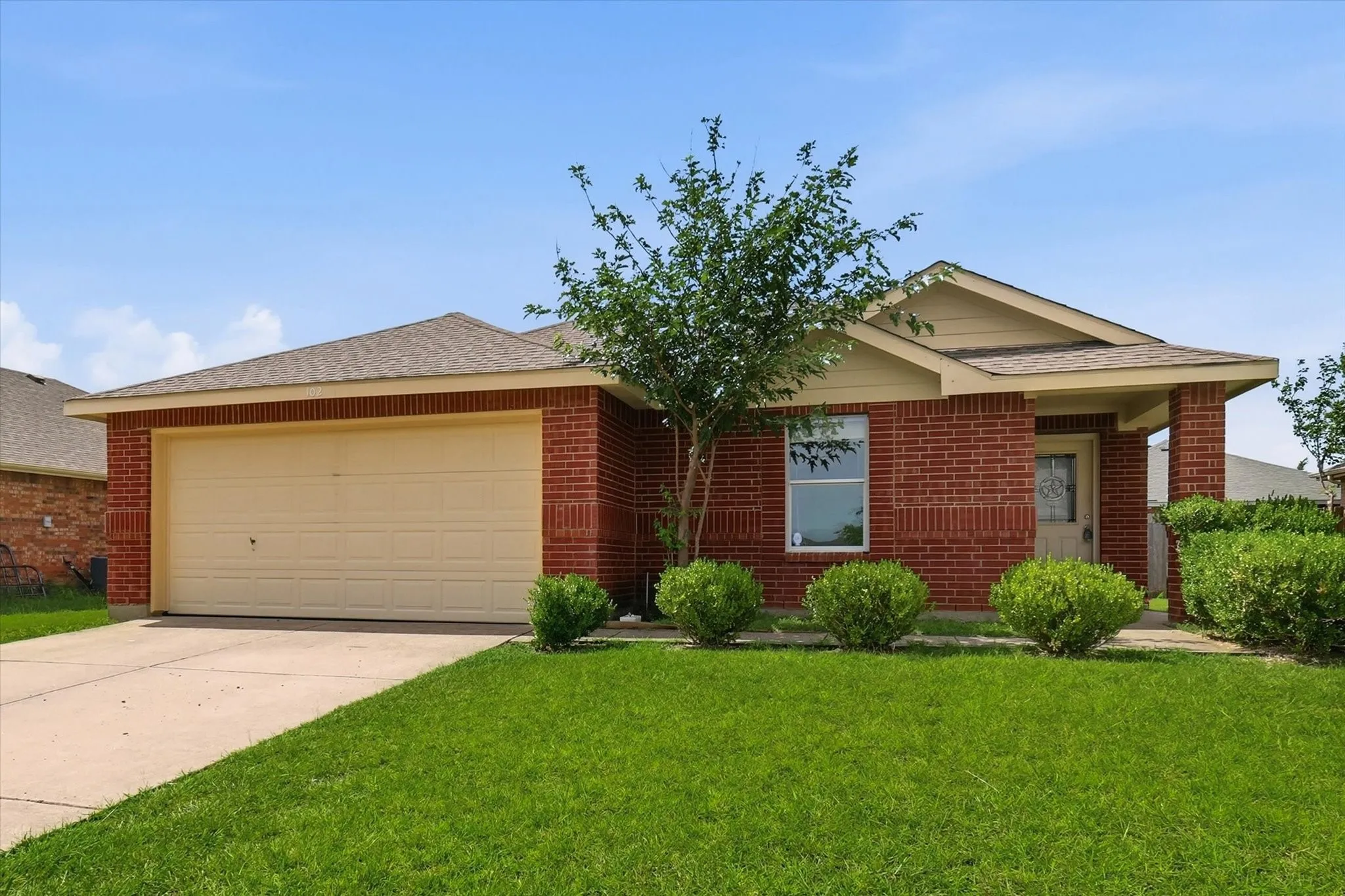 Brick exterior residence with a covered entryway and an attached two-car garage