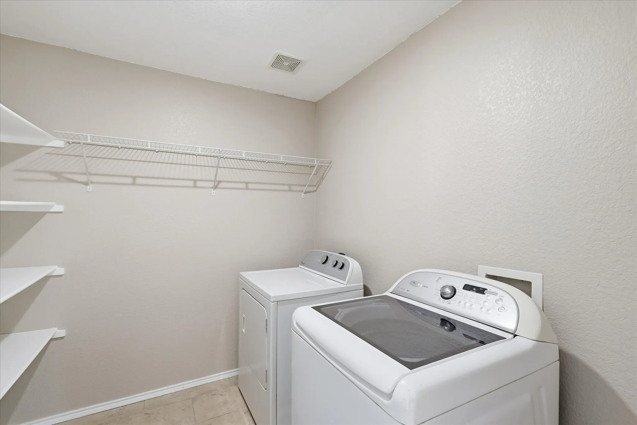 Utility room with neutral-toned walls and tile flooring