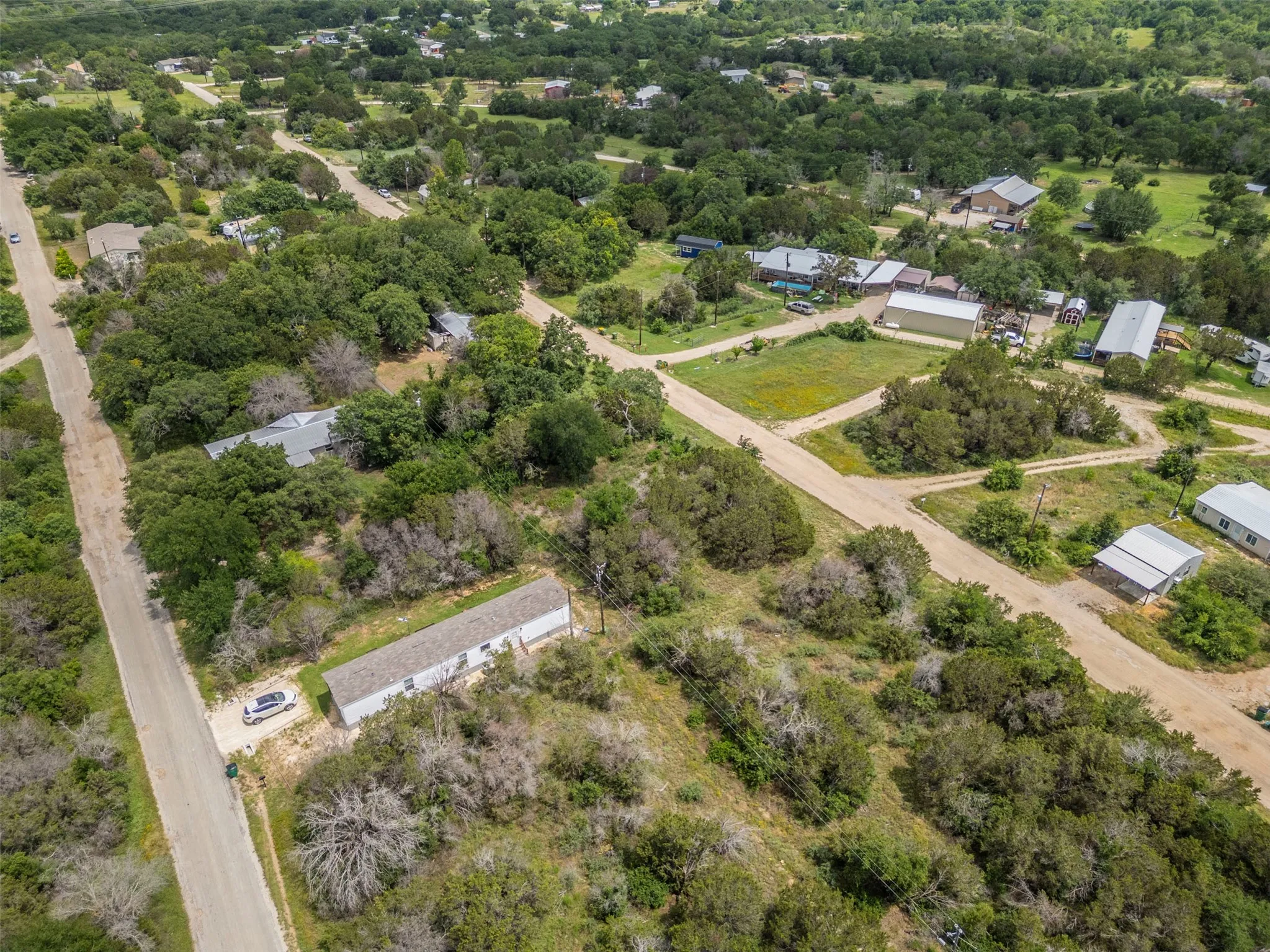 Expansive undeveloped land featuring mature trees and a gravel road