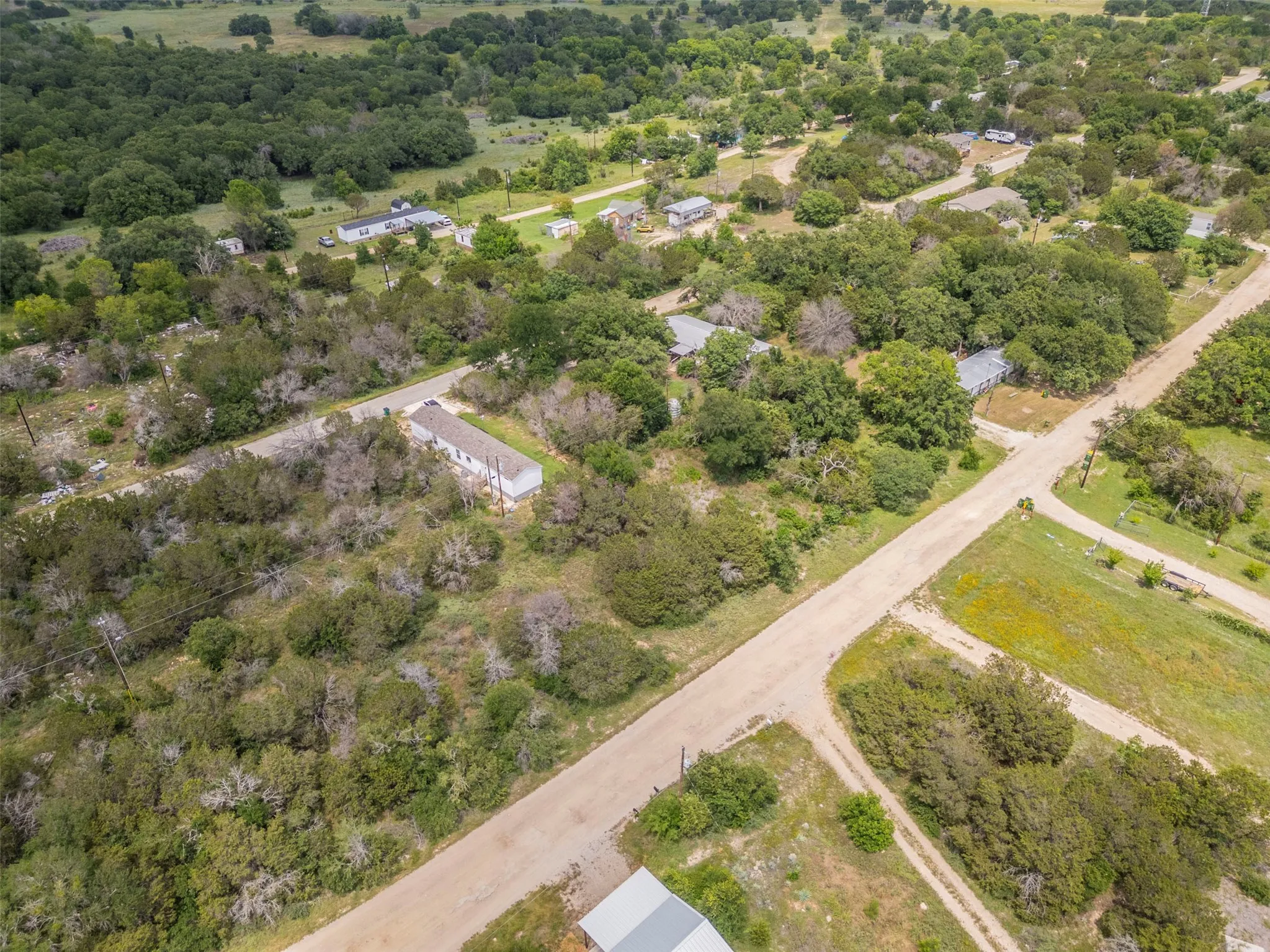 Expansive aerial perspective showcasing multiple properties amidst a verdant landscape