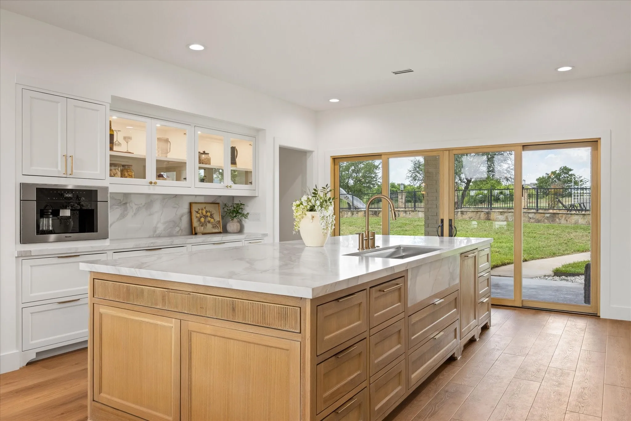 Impressive 12' x 5' Waterfall Island, with Large Farm Sink, Paneled Dishwasher, Built-In Miele Coffee System and Custom Cabinetry