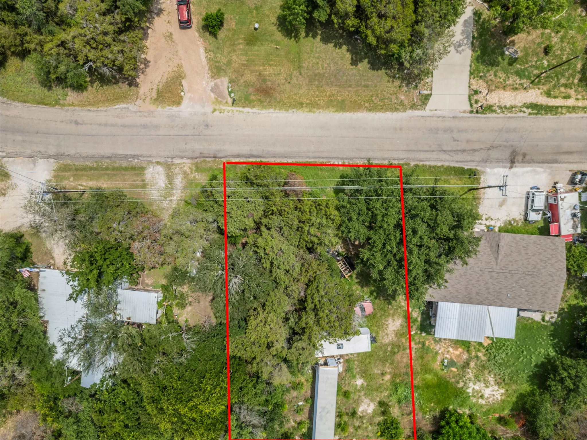 Expansive undeveloped lot featuring mature trees and direct road frontage