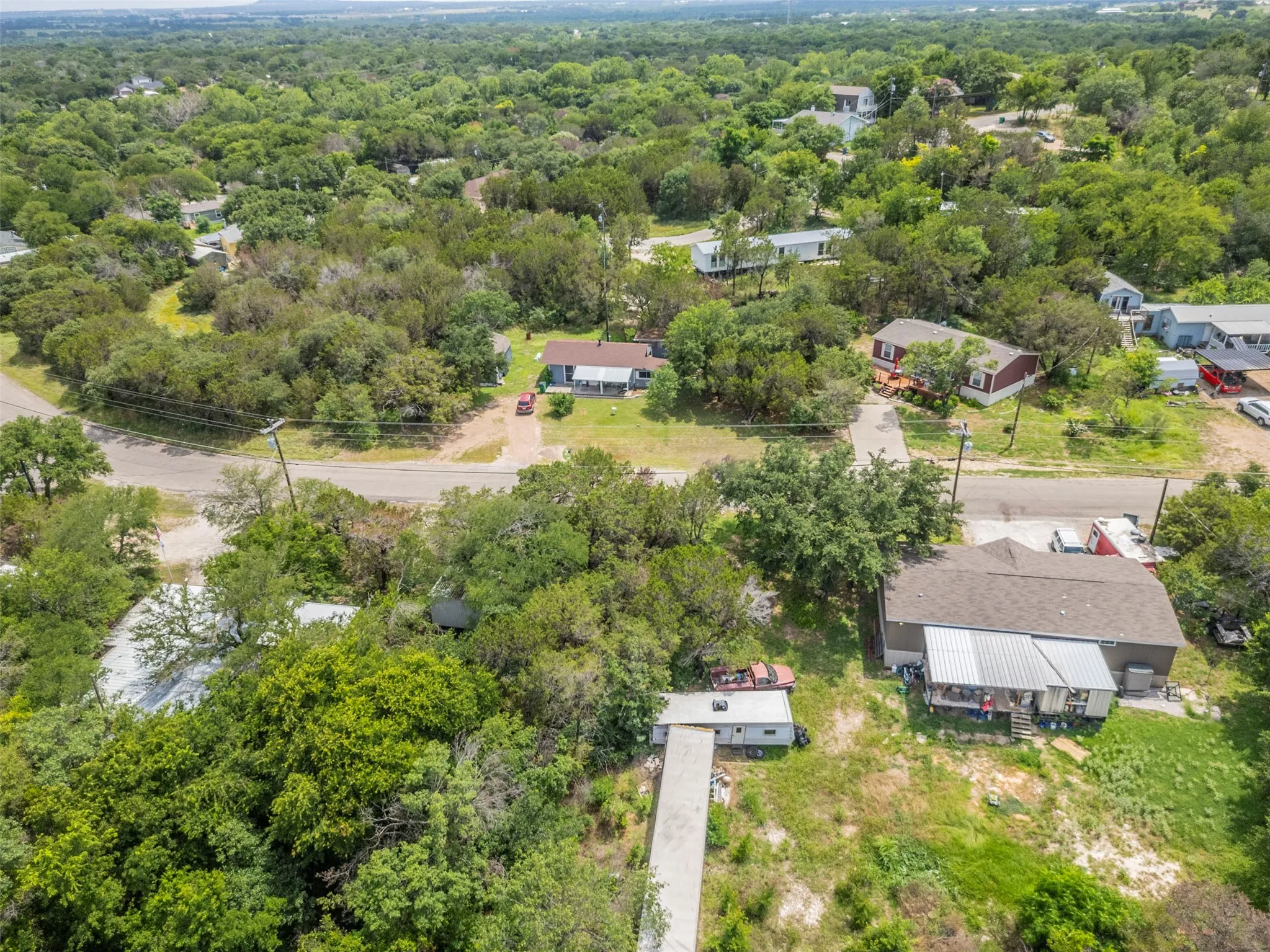 Aerial perspective showcasing multiple properties amidst abundant mature trees