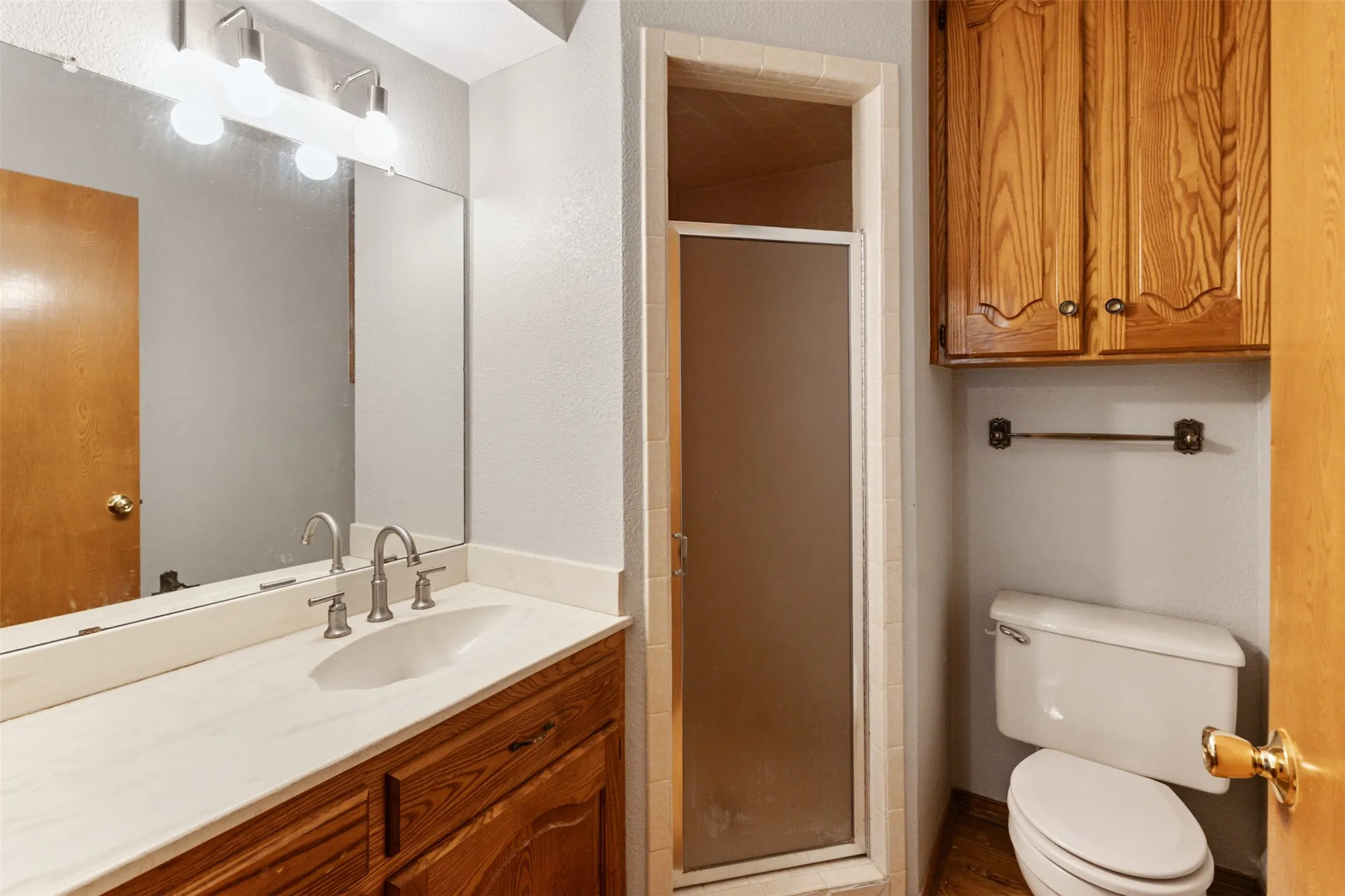 Bathroom featuring a single vanity with an integrated sink, a white countertop, and a brushed nickel faucet