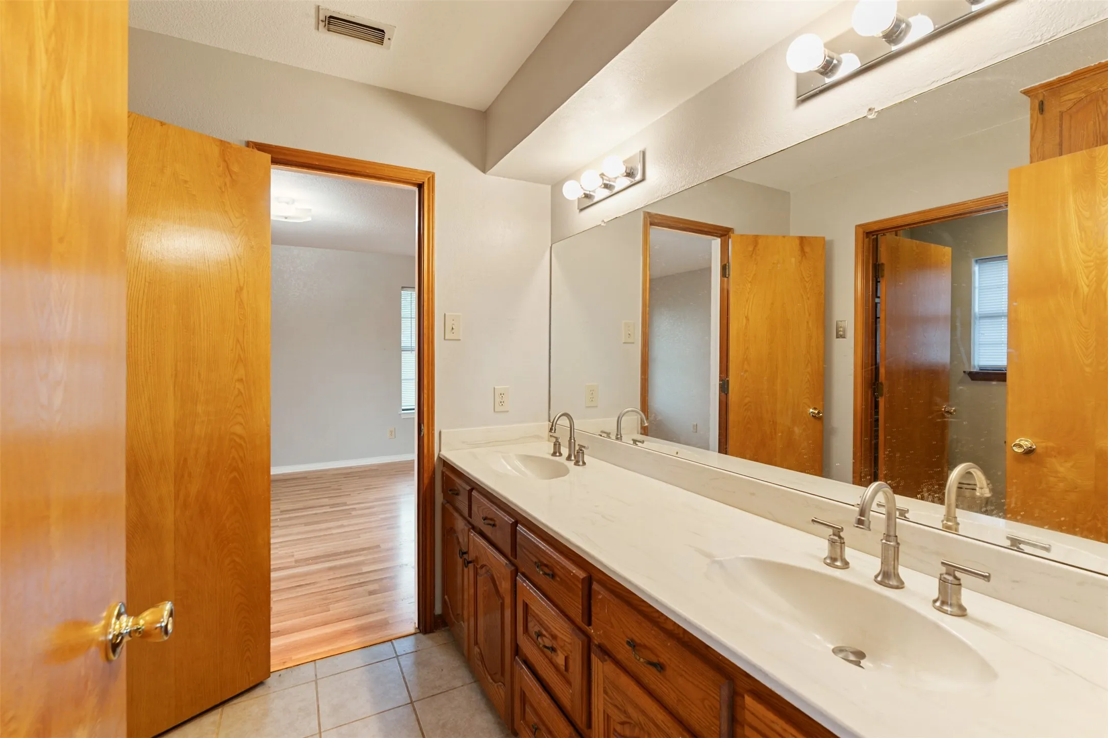 Dual vanity with white countertops, integrated sinks, and brushed nickel fixtures