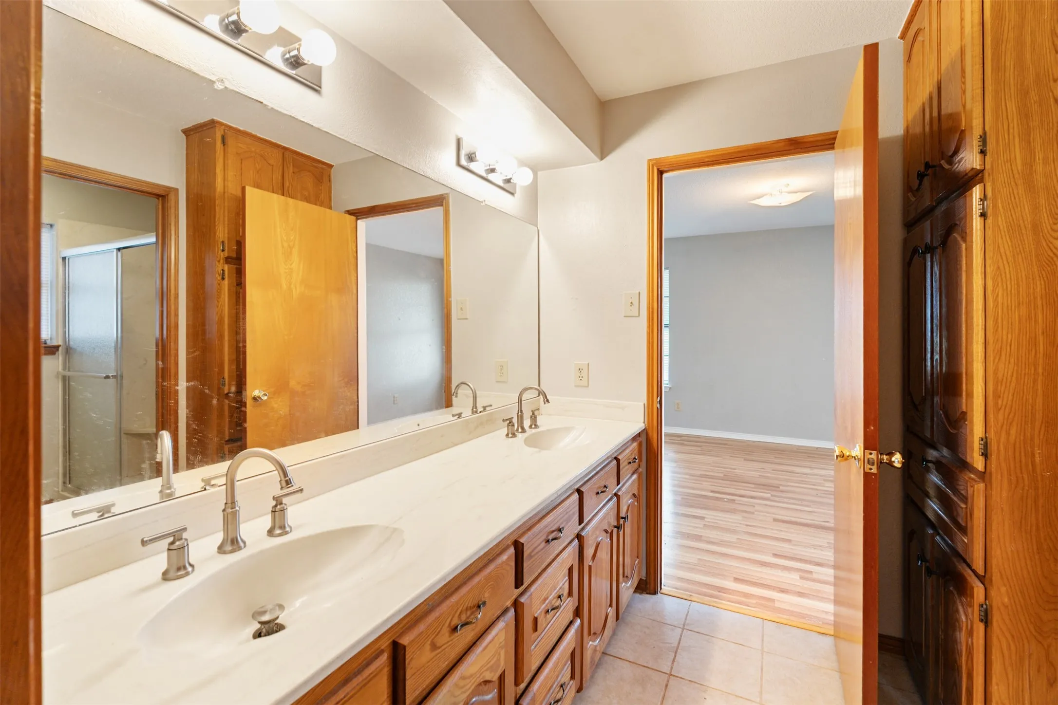 Dual vanity with undermount sinks and individual brushed nickel faucets, set in a white countertop