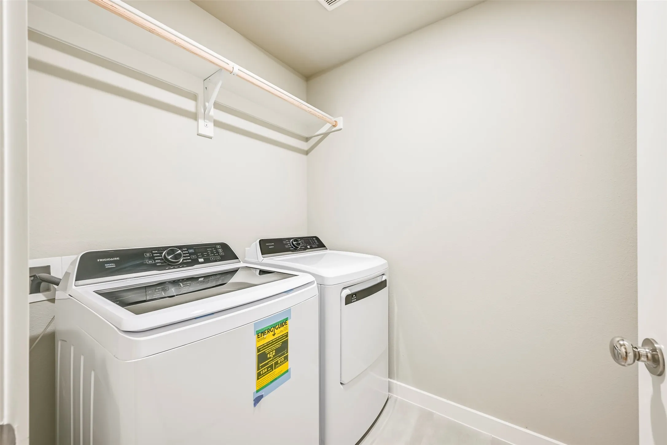Dedicated laundry area featuring a hanging rod and neutral wall finishes