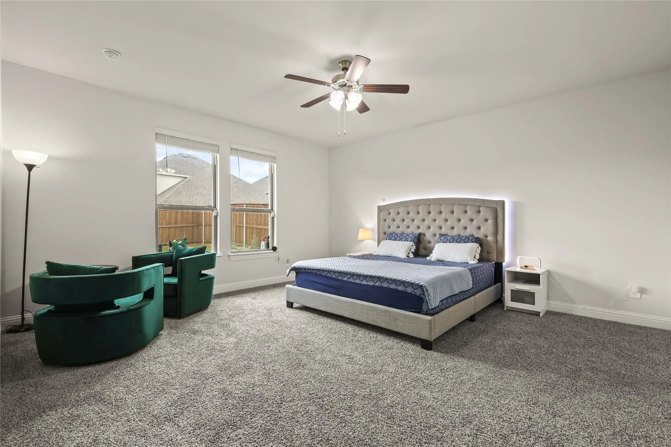 Spacious interior room featuring light-colored walls and plush carpeting