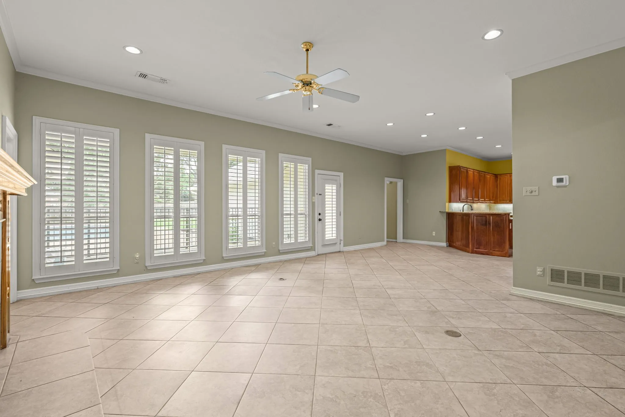 Spacious room featuring light-toned tile flooring, recessed lighting, and a ceiling fan