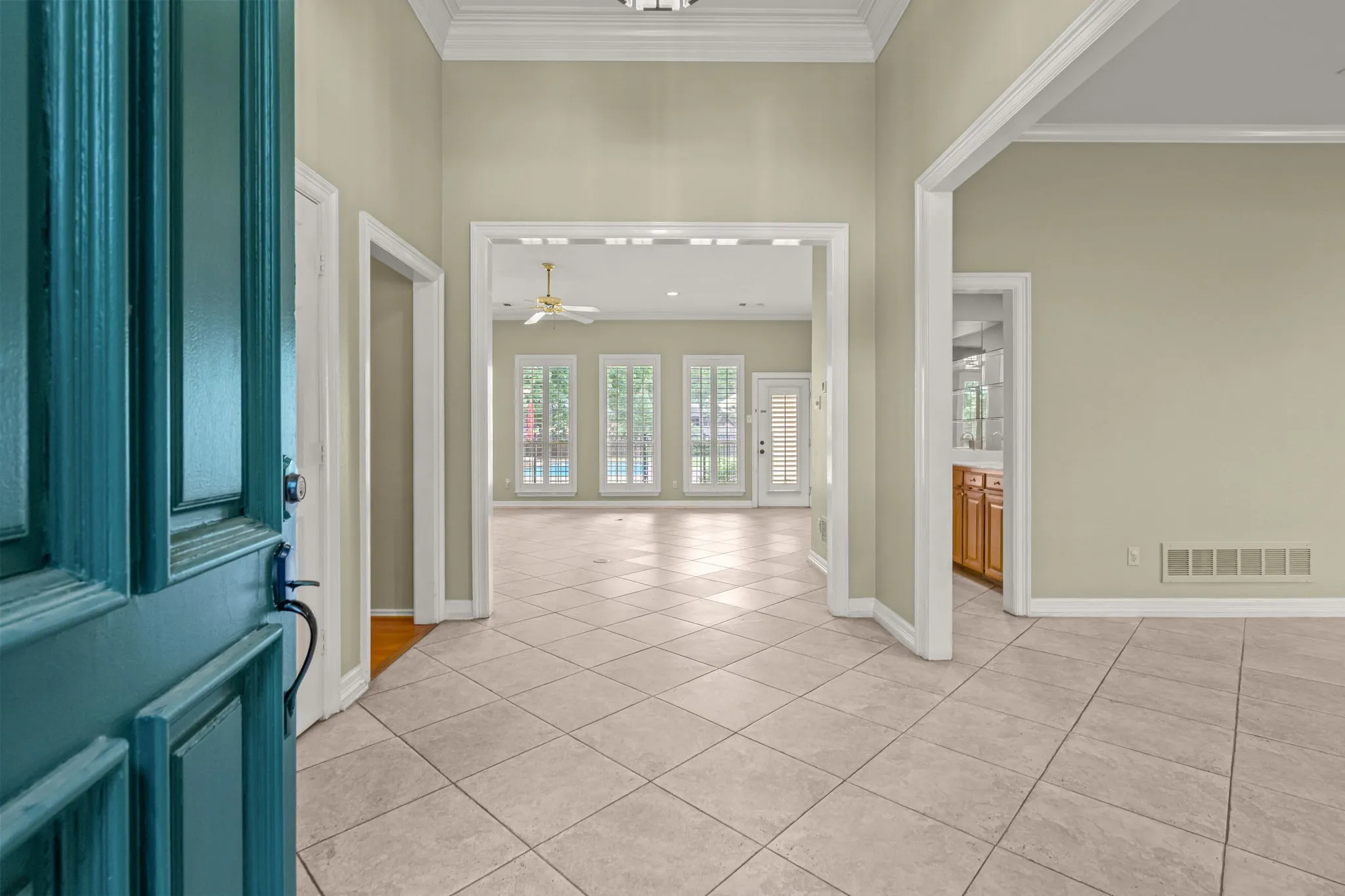 Entry foyer with light-toned square tile flooring extending into an open-concept living area