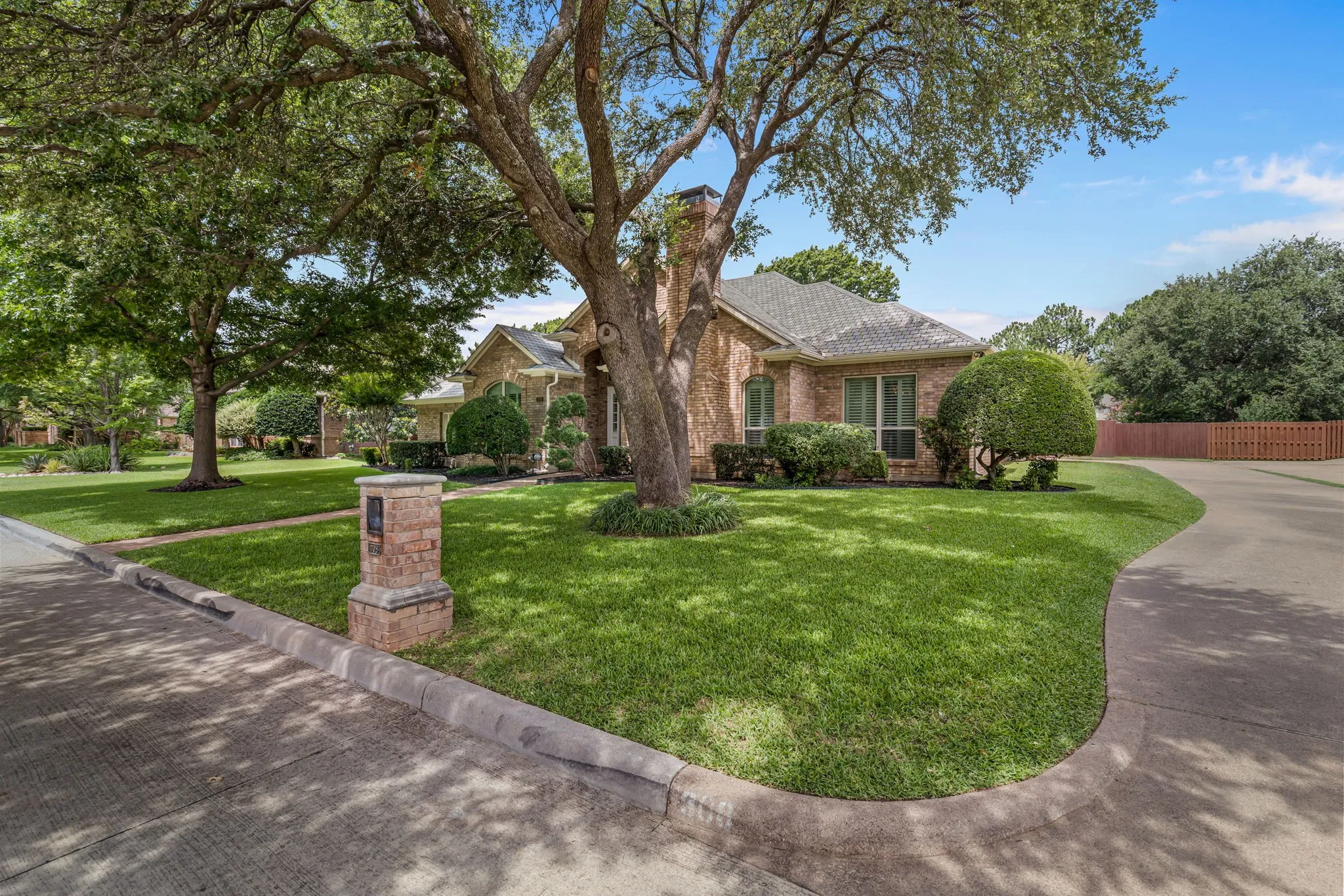Brick exterior with a gabled roof and a well-maintained front lawn