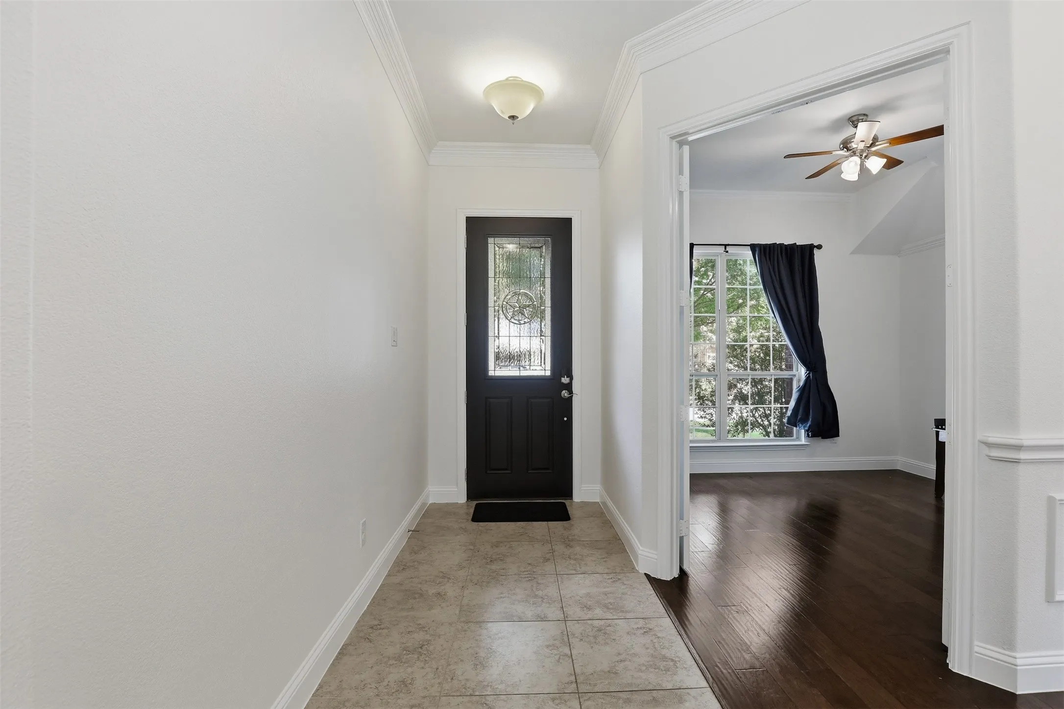 Entryway featuring tile flooring, a dark-paneled door with decorative glass, and a flush-mount ceiling light
