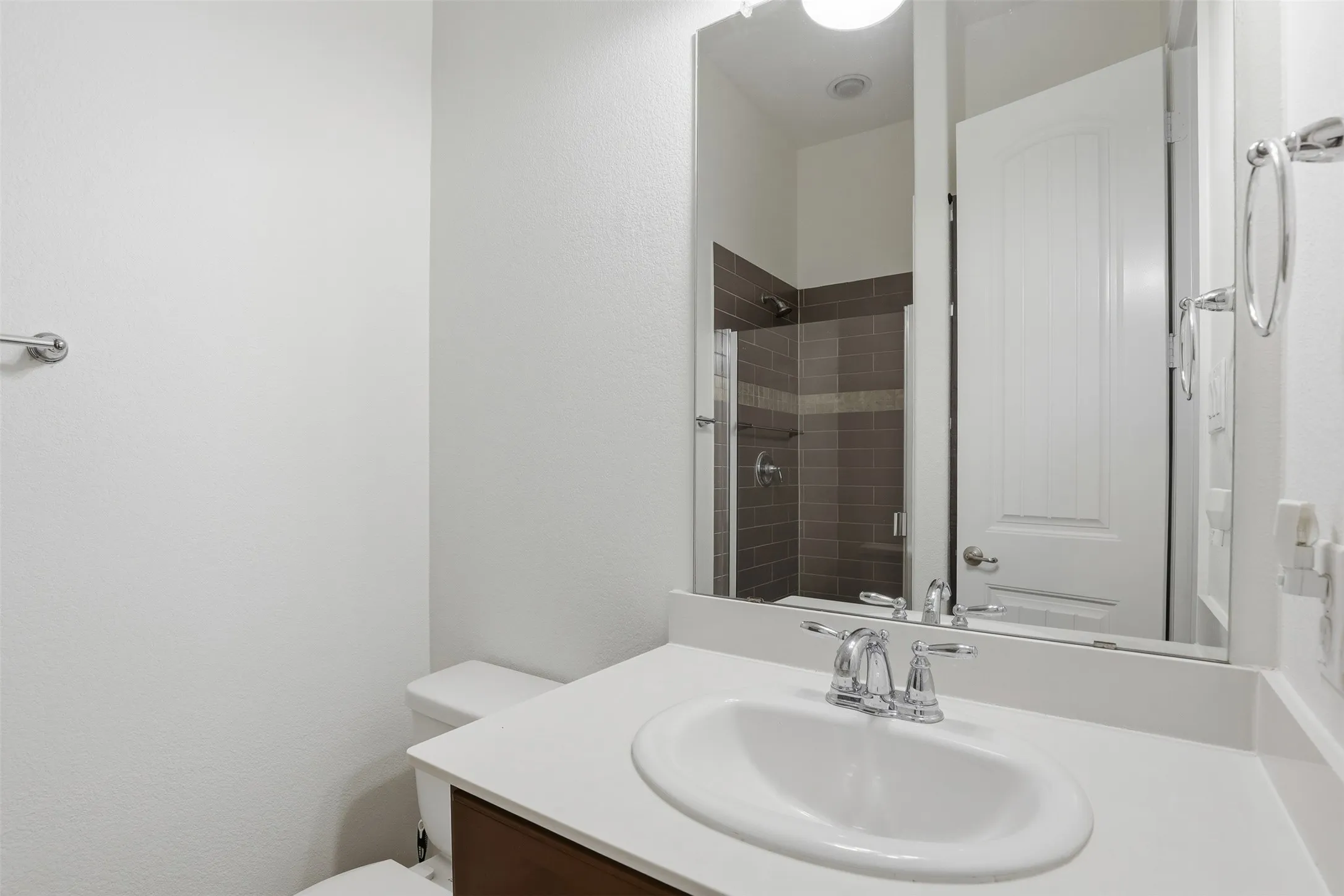 Modern bathroom featuring a single vanity with an integrated sink, chrome faucet, and white countertop