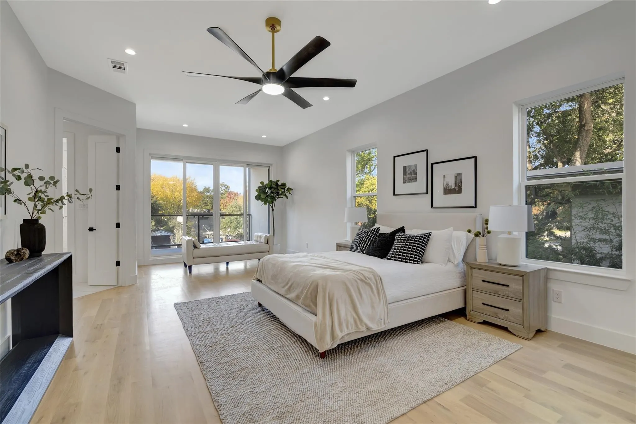 Expansive room featuring light wood-finish flooring, recessed lighting, and a modern ceiling fan