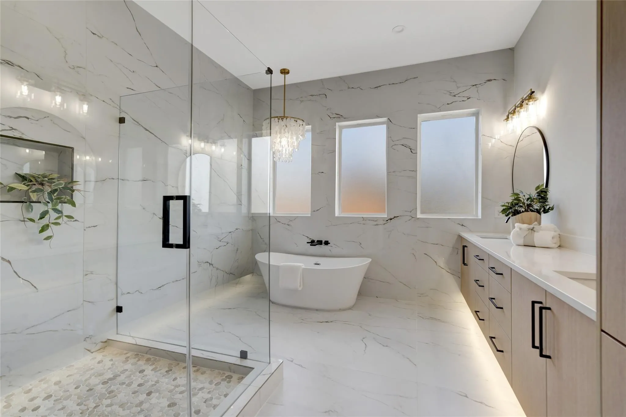 Spacious bathroom featuring large format tile flooring and wall finishes