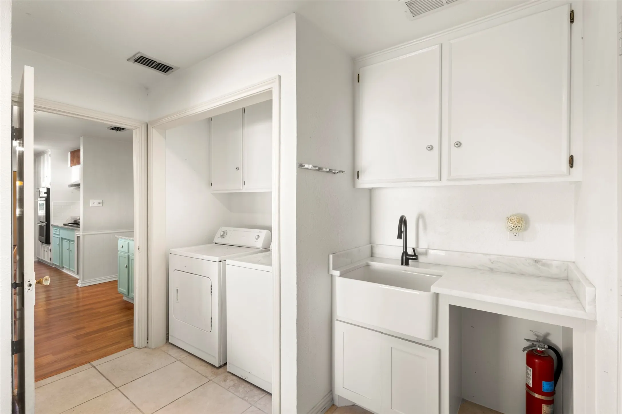 Utility room with extra storage, pantry, sink, and room for freezer