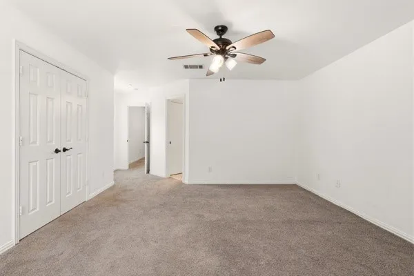 Spacious room featuring neutral carpet flooring and white walls