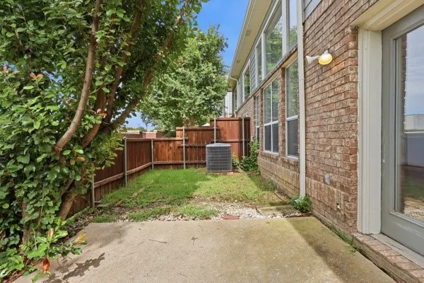 Outdoor patio area featuring a concrete slab and fenced perimeter
