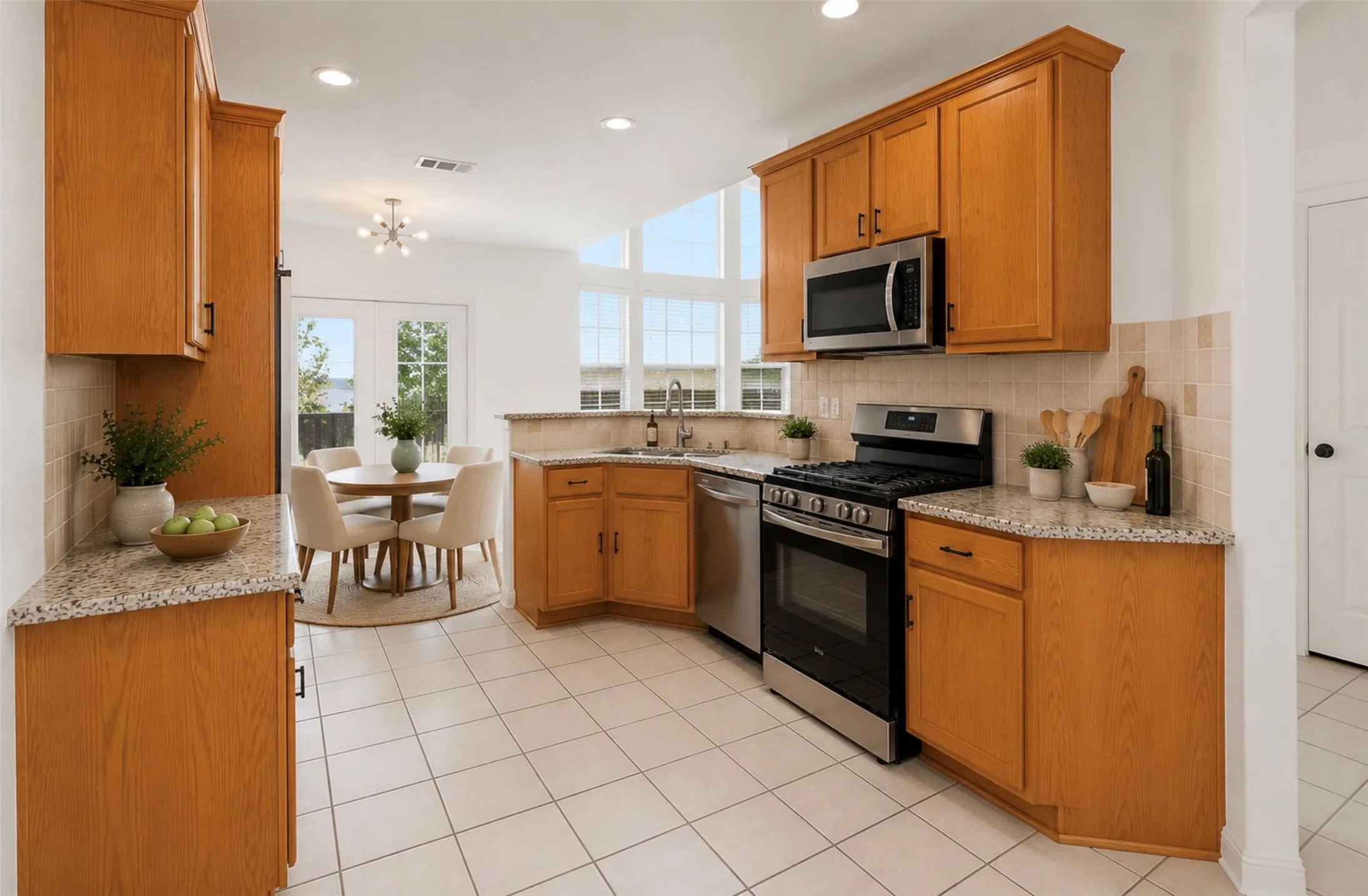 Open-concept kitchen featuring wood cabinetry, light-toned countertops, and stainless steel appliances, including a built-in microwave and gas range