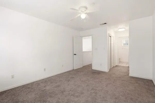 Carpeted interior space with white walls and baseboards