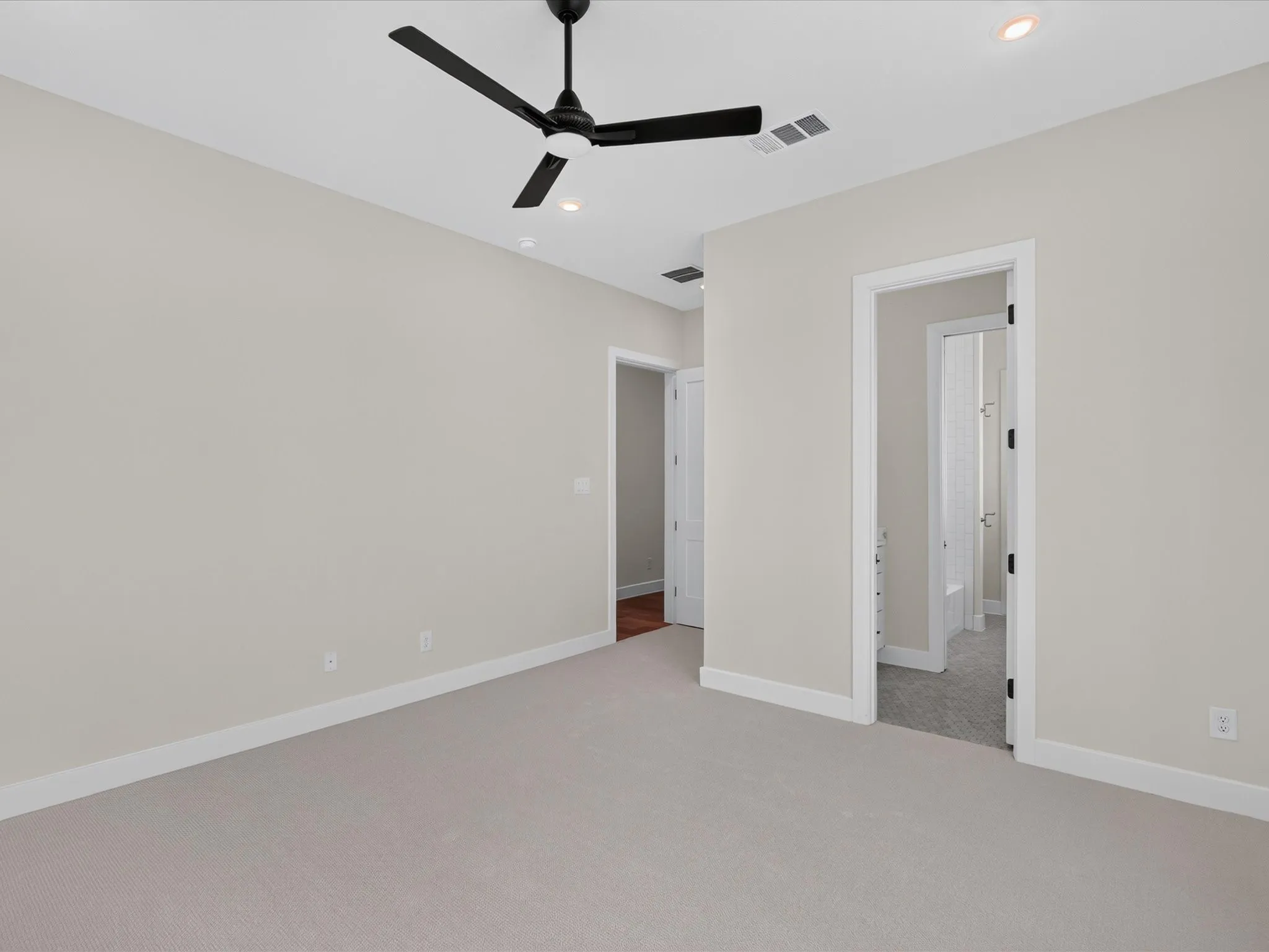 Recessed lighting, ceiling fan, neutral wall color, light-colored carpeting, white trim