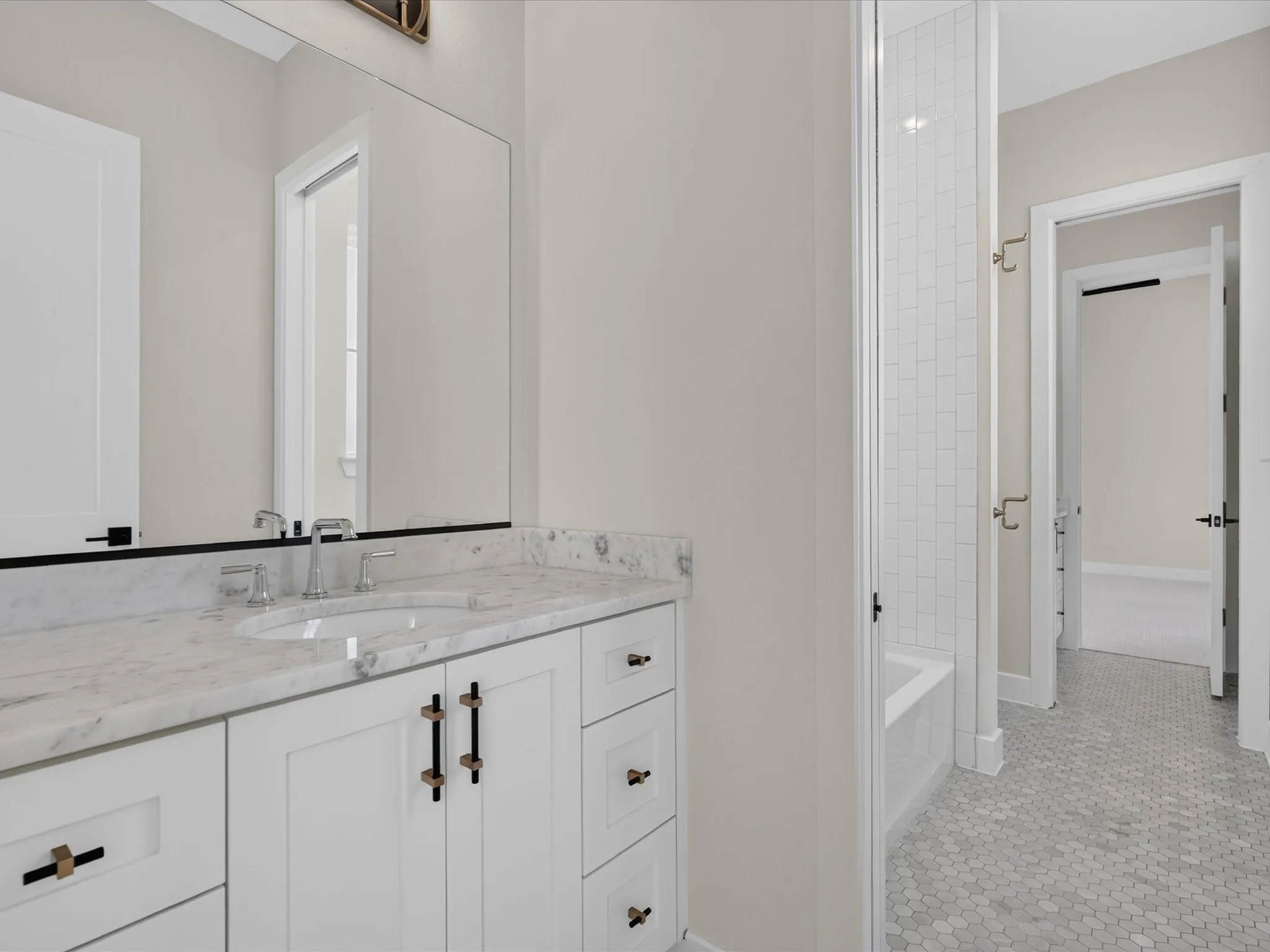 Vanity featuring white cabinetry, a single undermount sink, and a stone countertop