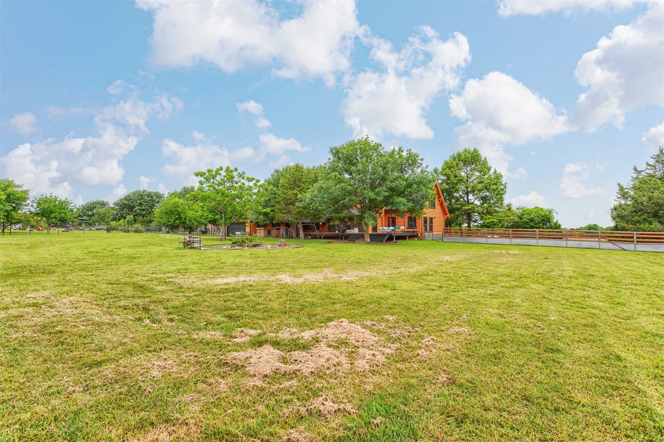View of the back of the home and deck area from the SE corner of the property