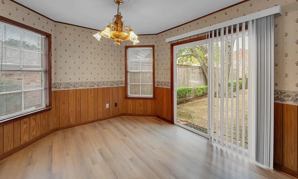 Breakfast Nook featuring fresh Luxury Viynal Plank, Half-Wall Wood Paneling, and a Sliding Glass Door to the Back Patio.