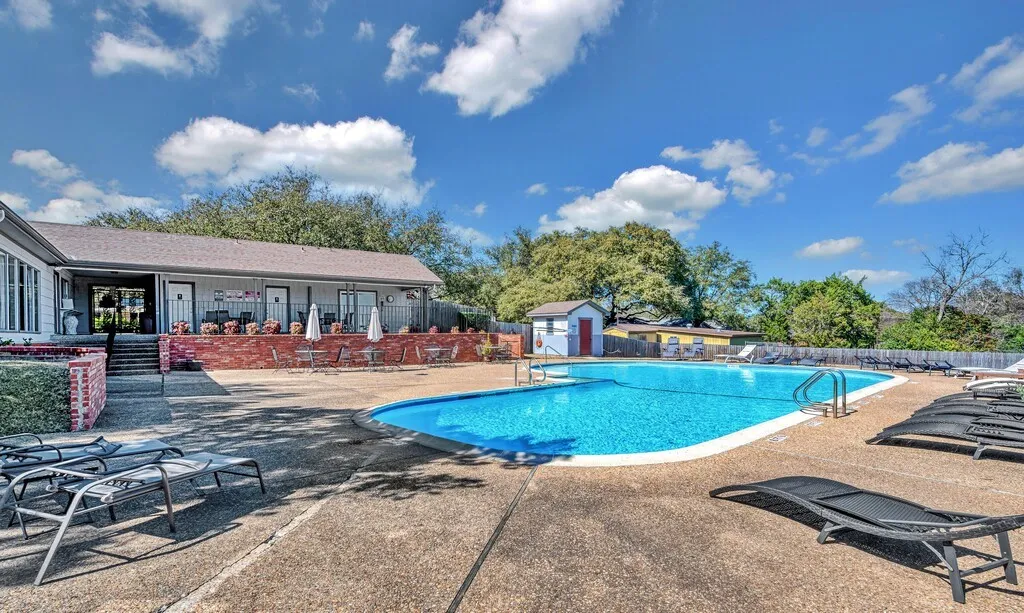 Community Resort-style outdoor pool with a gravel aggregate deck and a surrounding privacy fence
