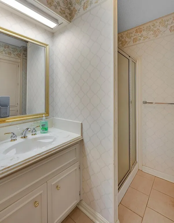 Bathroom featuring a white vanity with an integrated sink and gold-tone hardware
