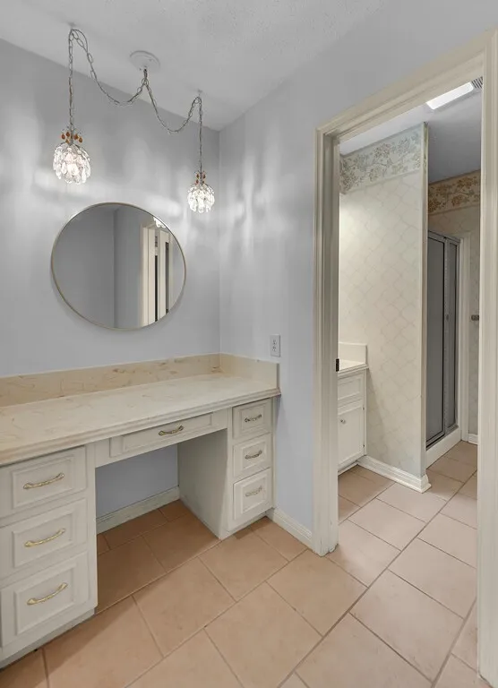 Built-in vanity with a round mirror, and decorative pendant lighting