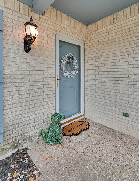 Light-colored brick exterior with a blue entry door