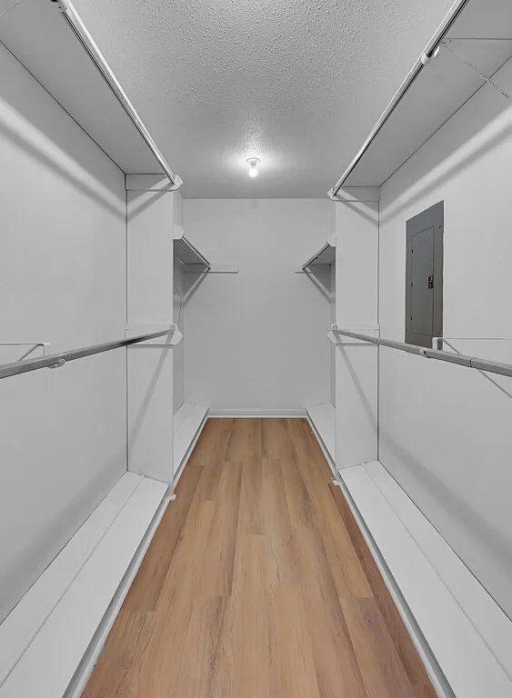 Primary Closet- Generous closet space featuring freshly painted white shelving, shoe shelving & hanging rods.