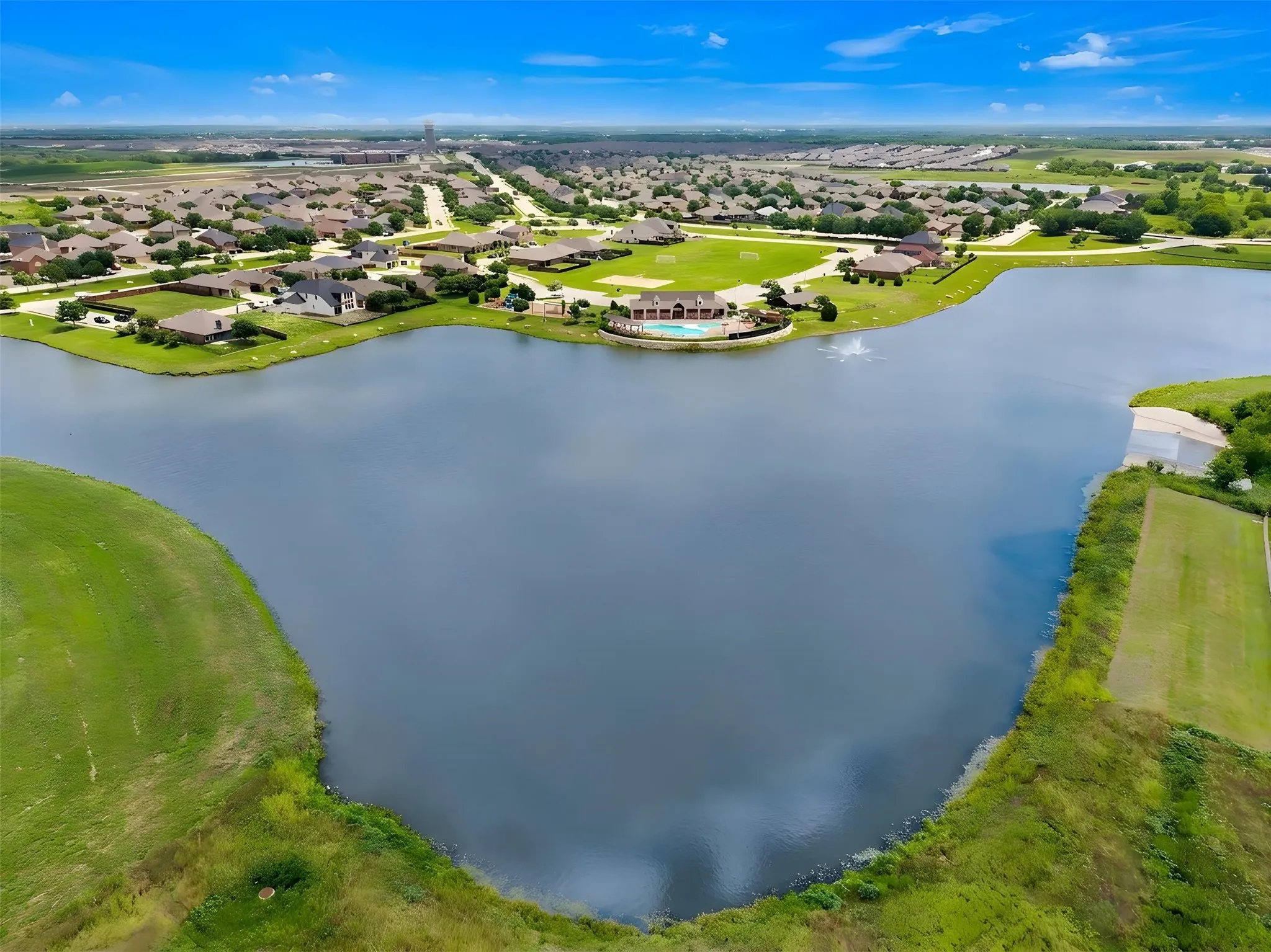 Expansive lake with surrounding properties and green spaces