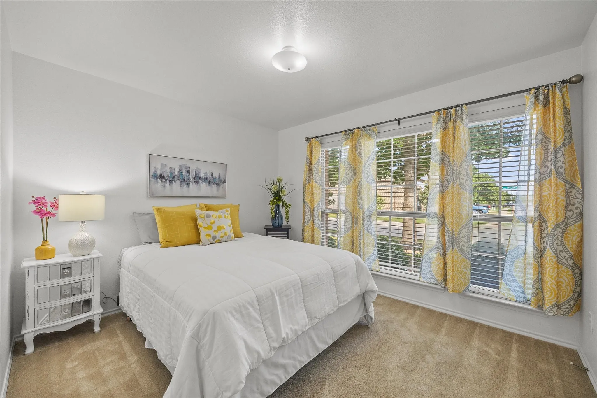 Carpeted room with multiple large windows, featuring white walls and a ceiling-mounted light fixture