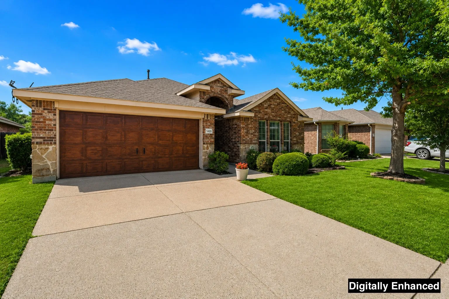 Brick and stone veneer facade with a wood-look garage door