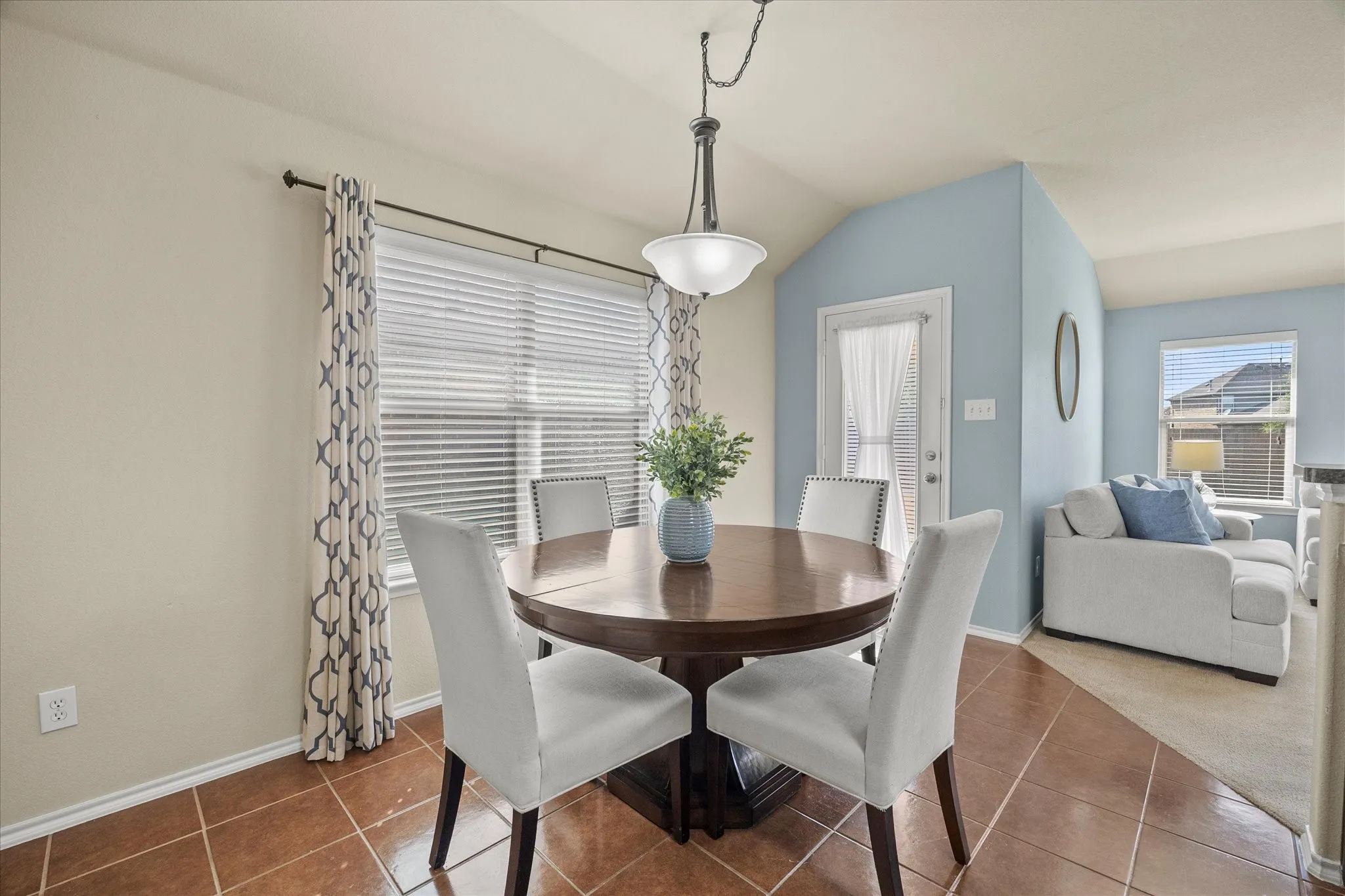 Breakfast nook featuring a built-in pendant light fixture, window blinds, and tile flooring