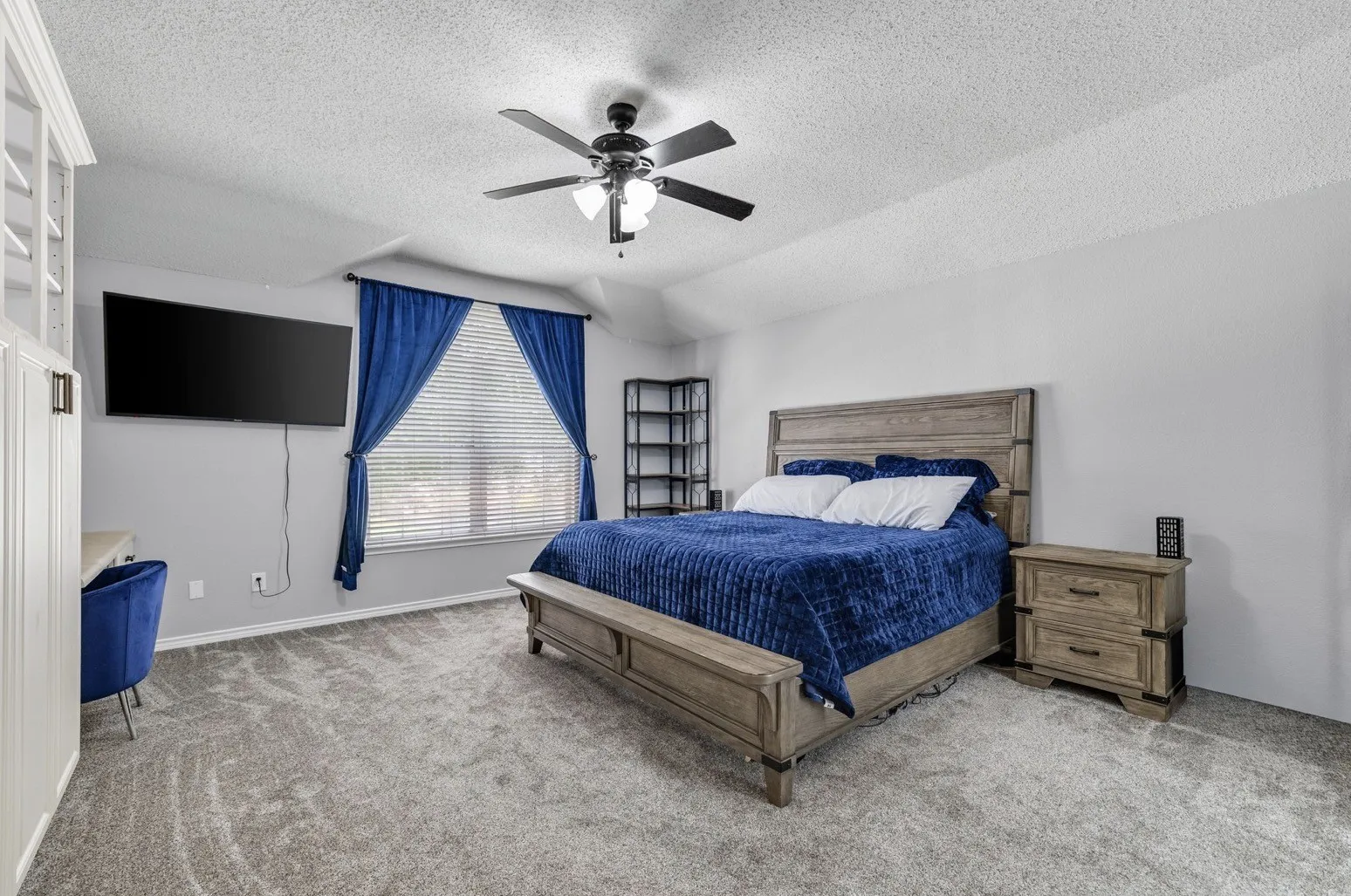 Spacious room featuring neutral carpet flooring and a ceiling fan