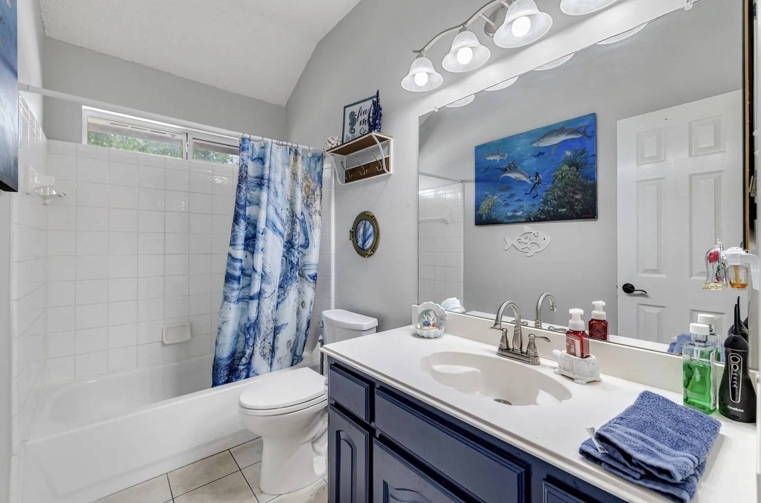 Bathroom featuring a white bathtub, ceramic tile surround, and a high window