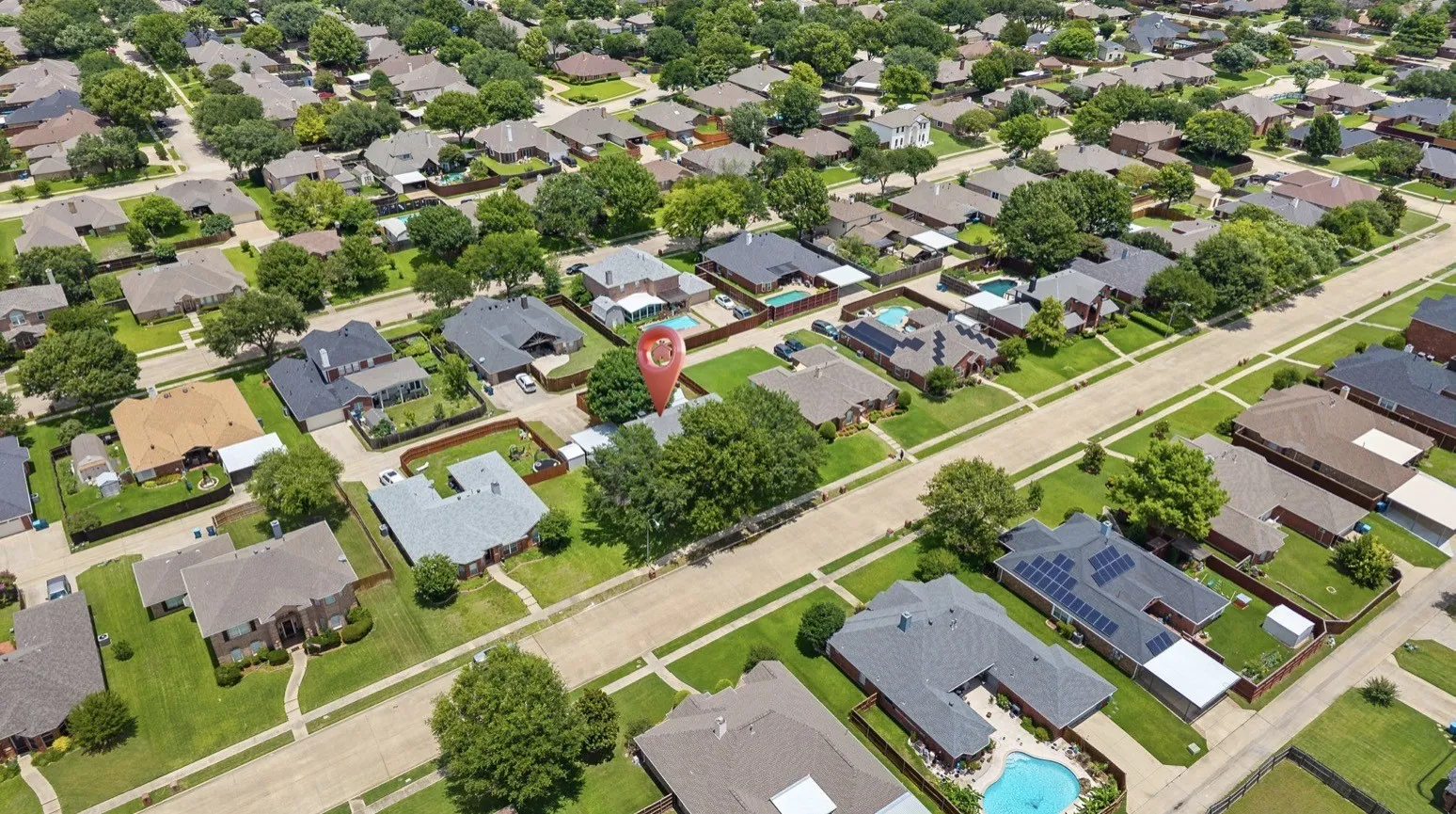 Residential neighborhood featuring diverse home styles, mature trees, and street-level sidewalks