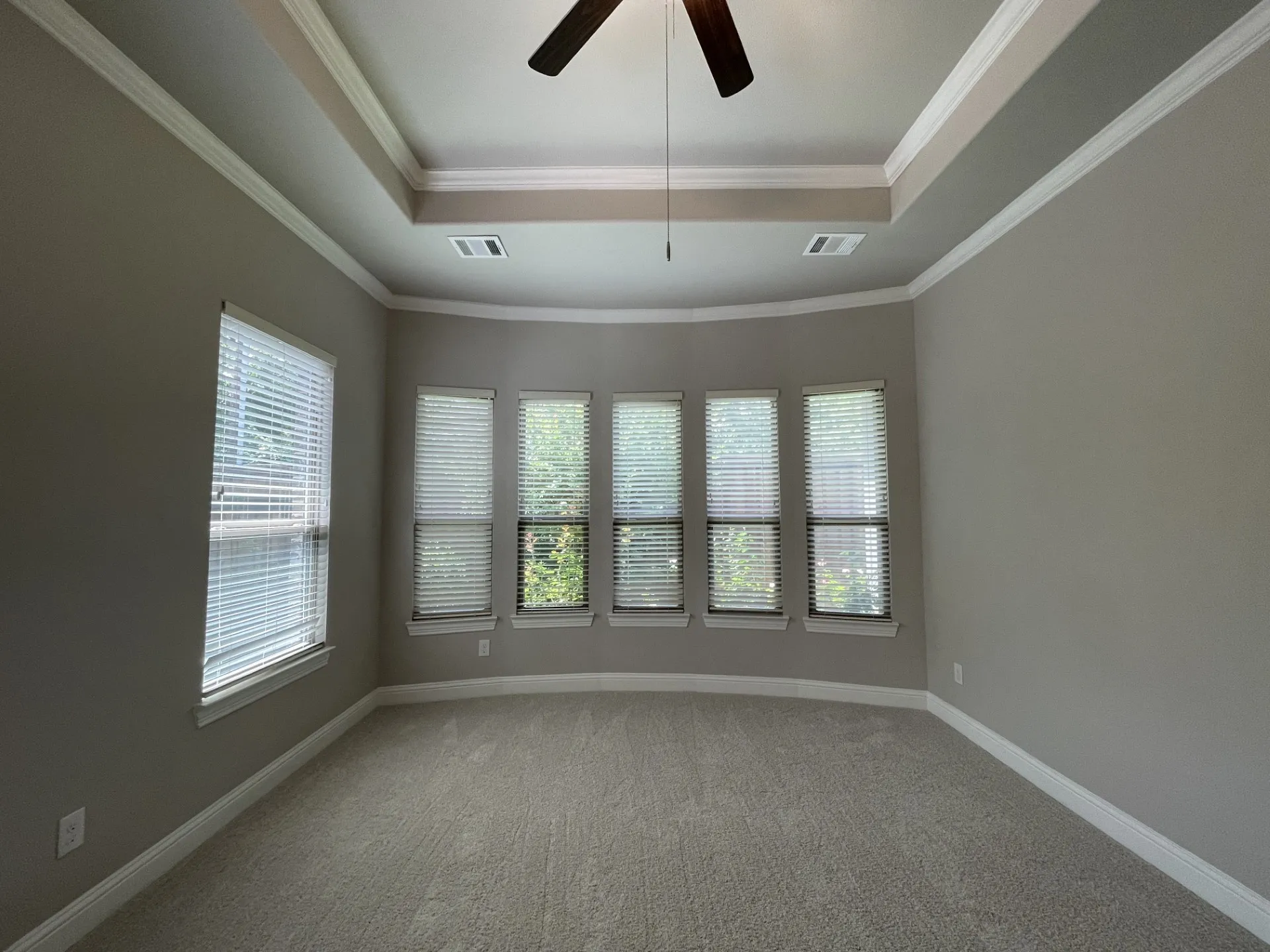 Tray ceiling with crown molding, ceiling fan, and recessed lighting