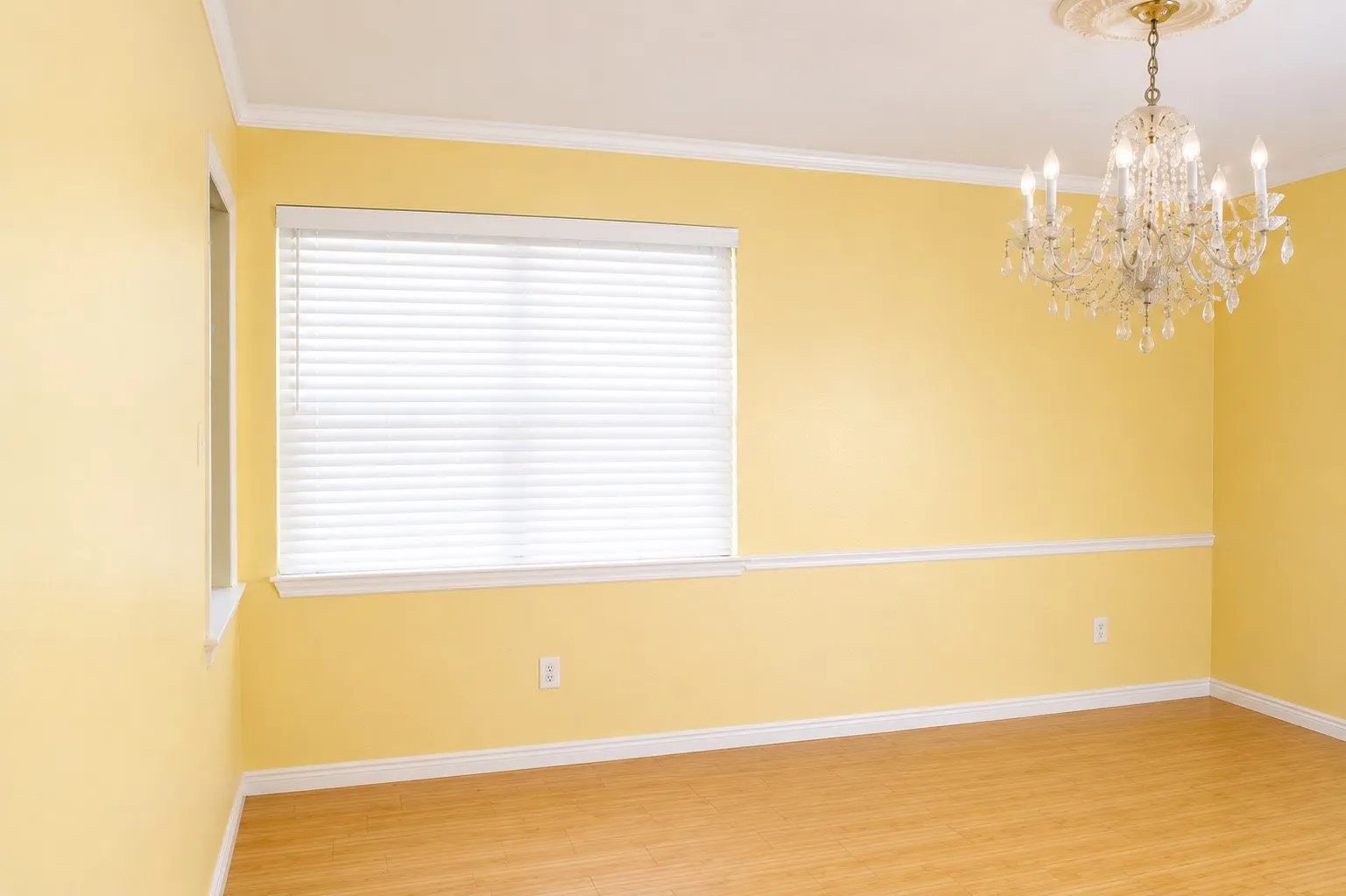 Room featuring wood-finish flooring, a large window with blinds, and white trim molding