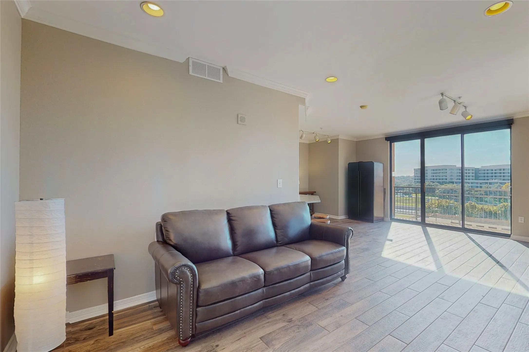 Living room featuring crown molding, rail lighting, and light wood-type flooring