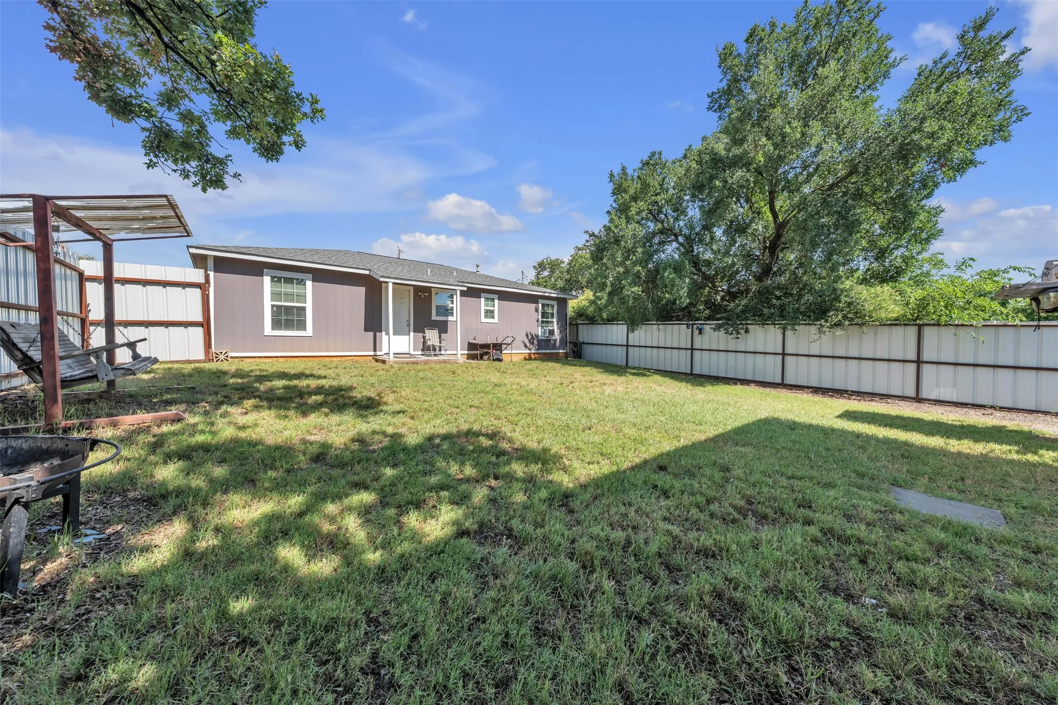 Expansive lawn area featuring a full privacy fence
