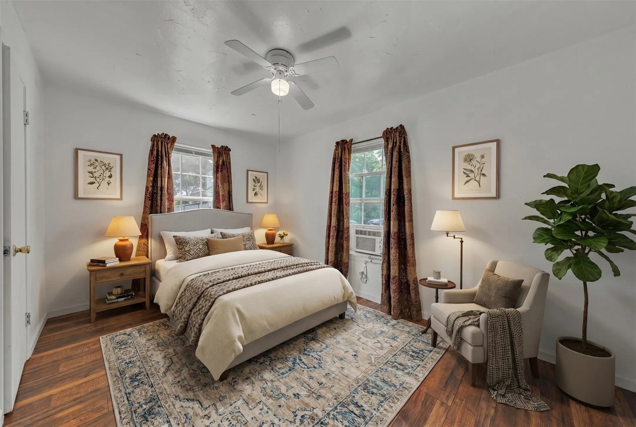 Bedroom with wood-finish flooring, two windows, and a ceiling fan with integrated lighting