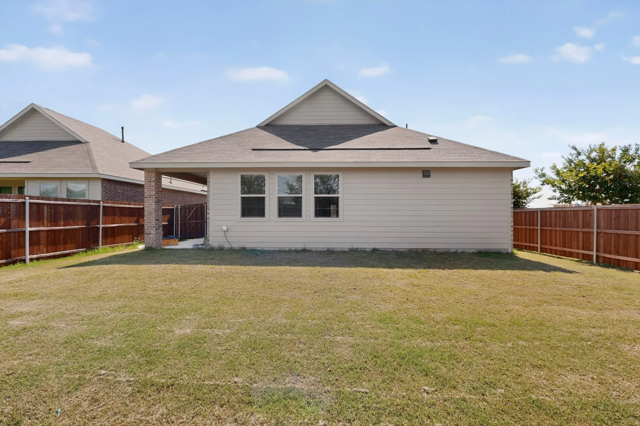 Expansive backyard featuring a manicured lawn and privacy fencing