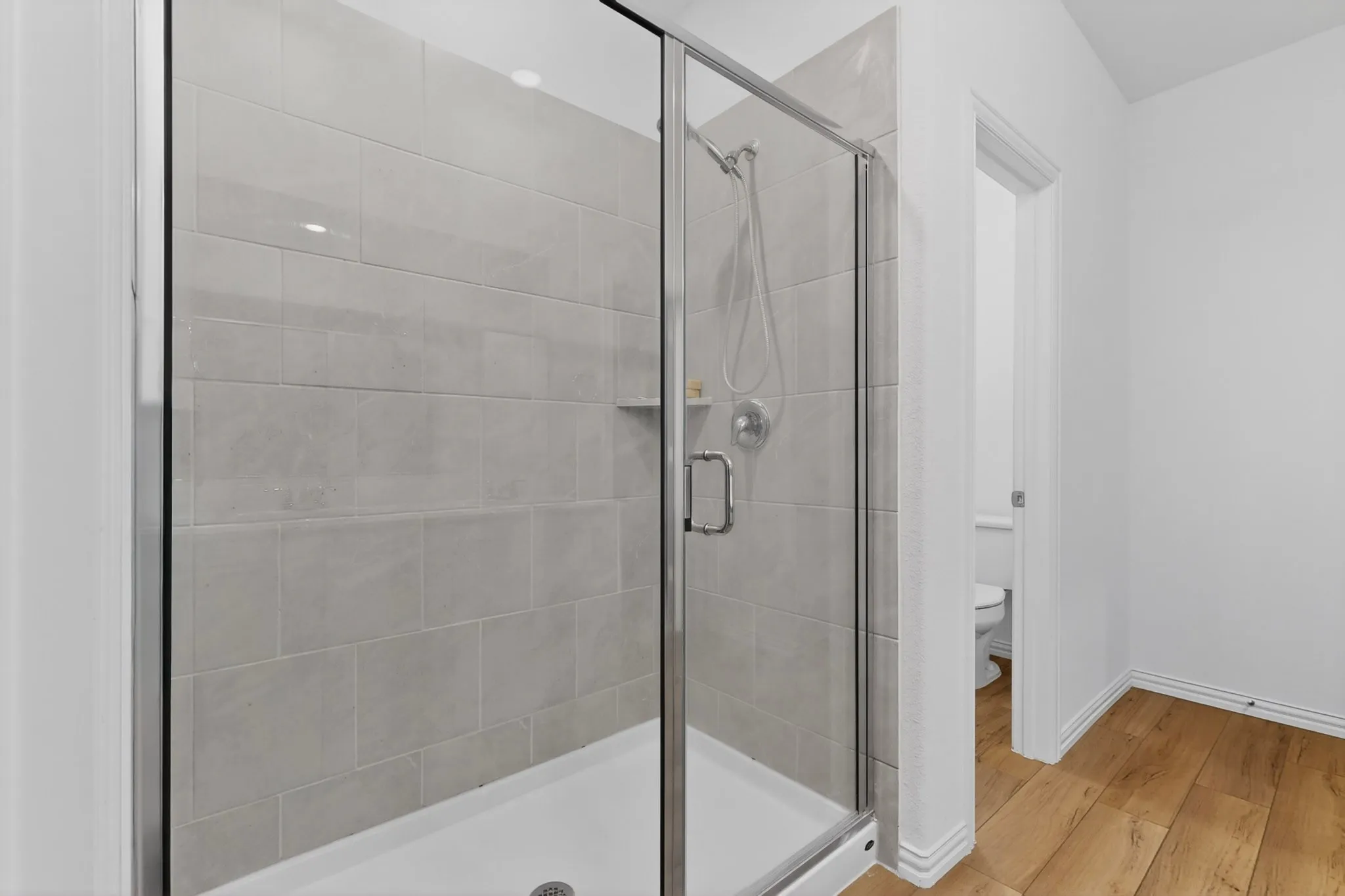 Shower enclosure with clear glass paneling and a chrome handle