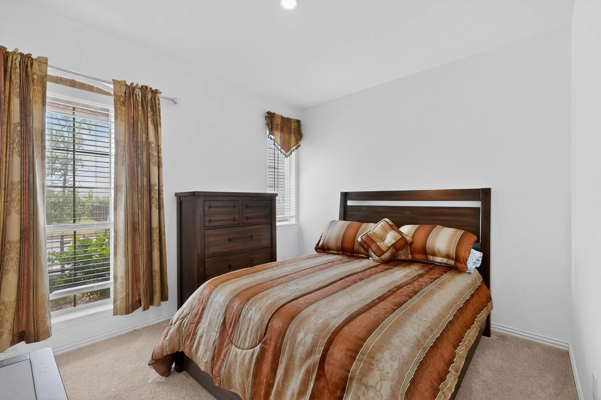 Carpeted room featuring multiple windows with blinds, white walls, and a recessed ceiling light