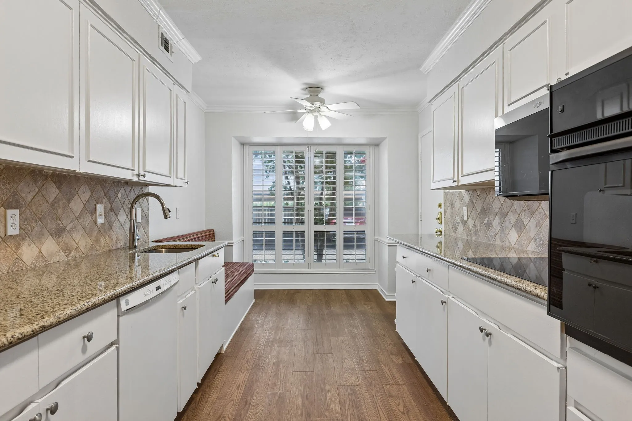 Kitchen features ample counter space, painted cabinets, and a large window that fills the space with natural light.