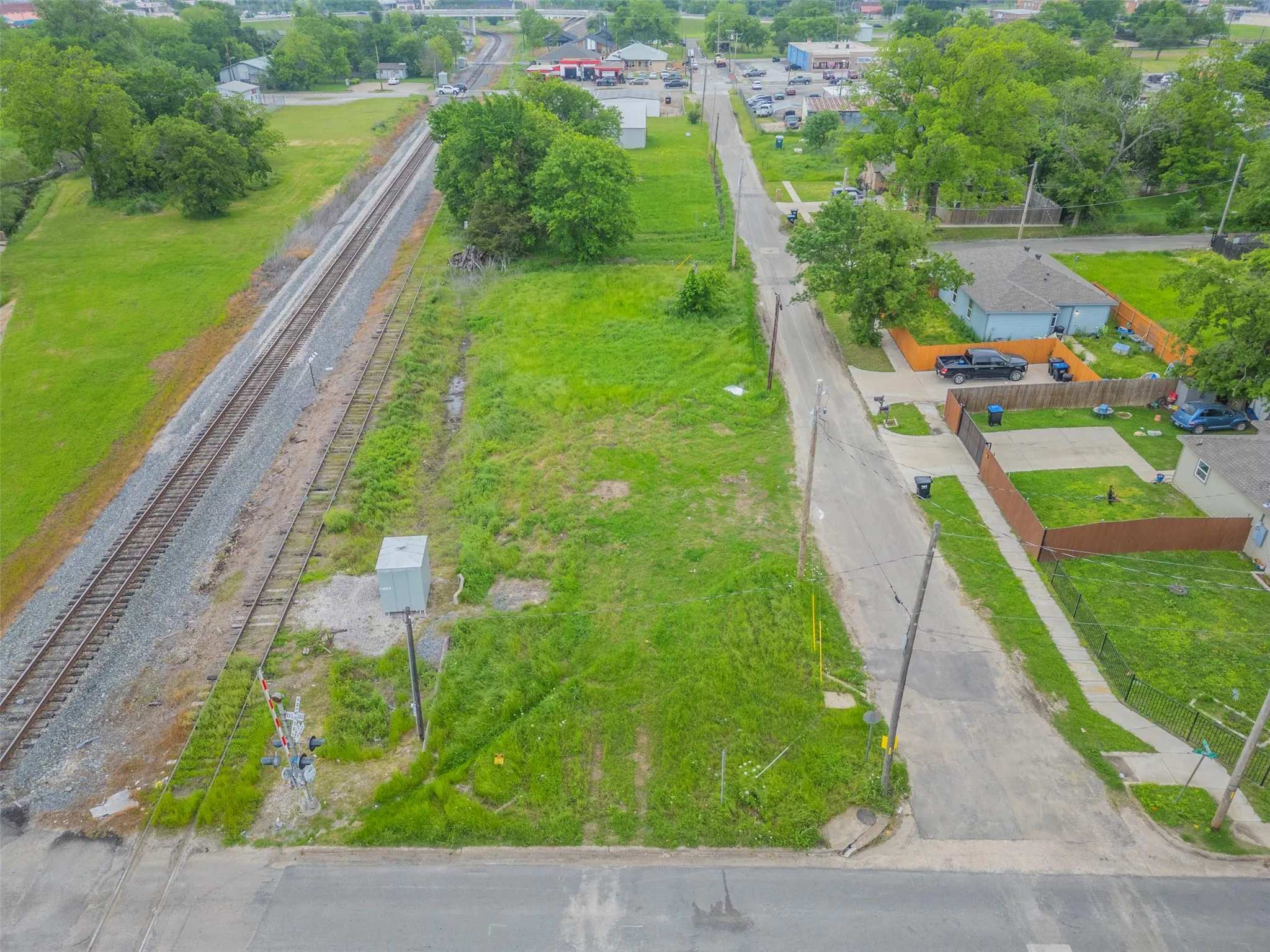 Expansive grass lot featuring street frontage, power pole, and utility box